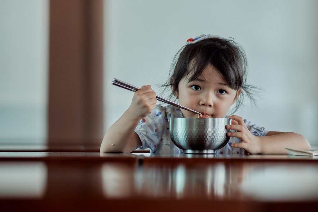 Niña comiendo sola