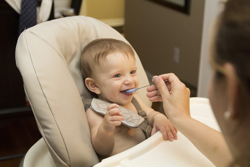 Niño comiendo con ayuda